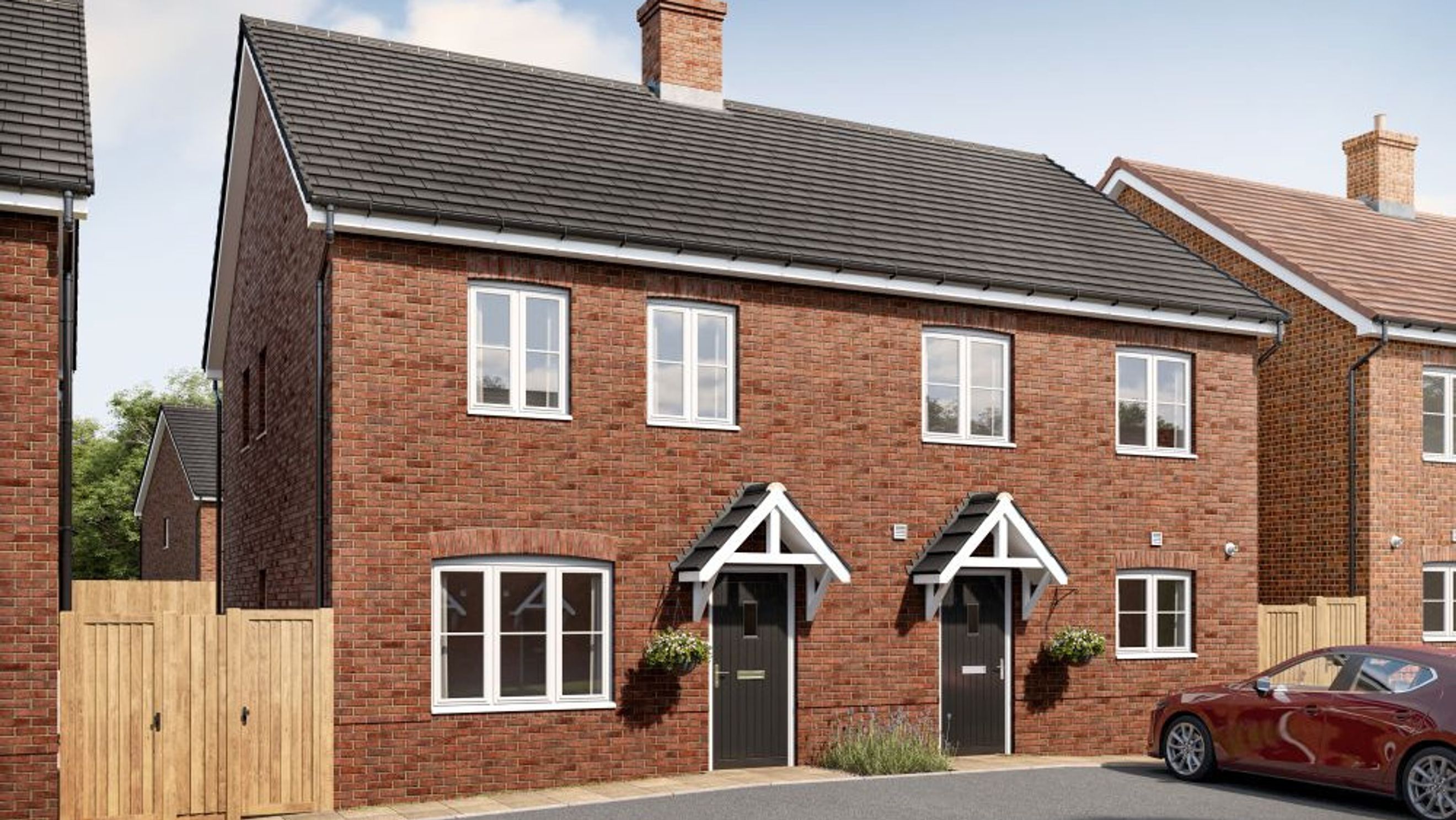A pair of brick houses with dark front doors and white-framed windows.