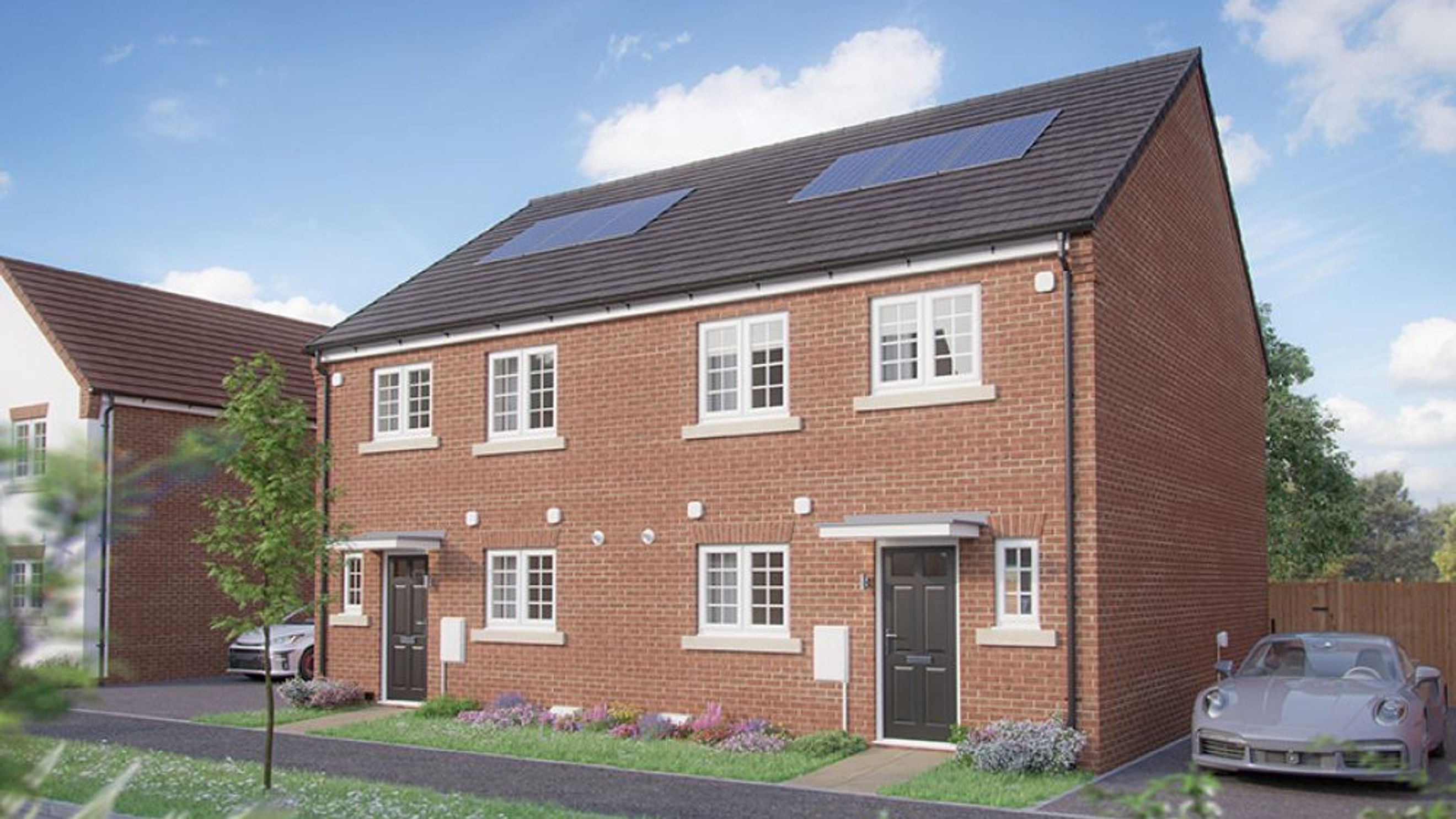A red brick semi-detached house with solar panels on the roof and white-framed windows.