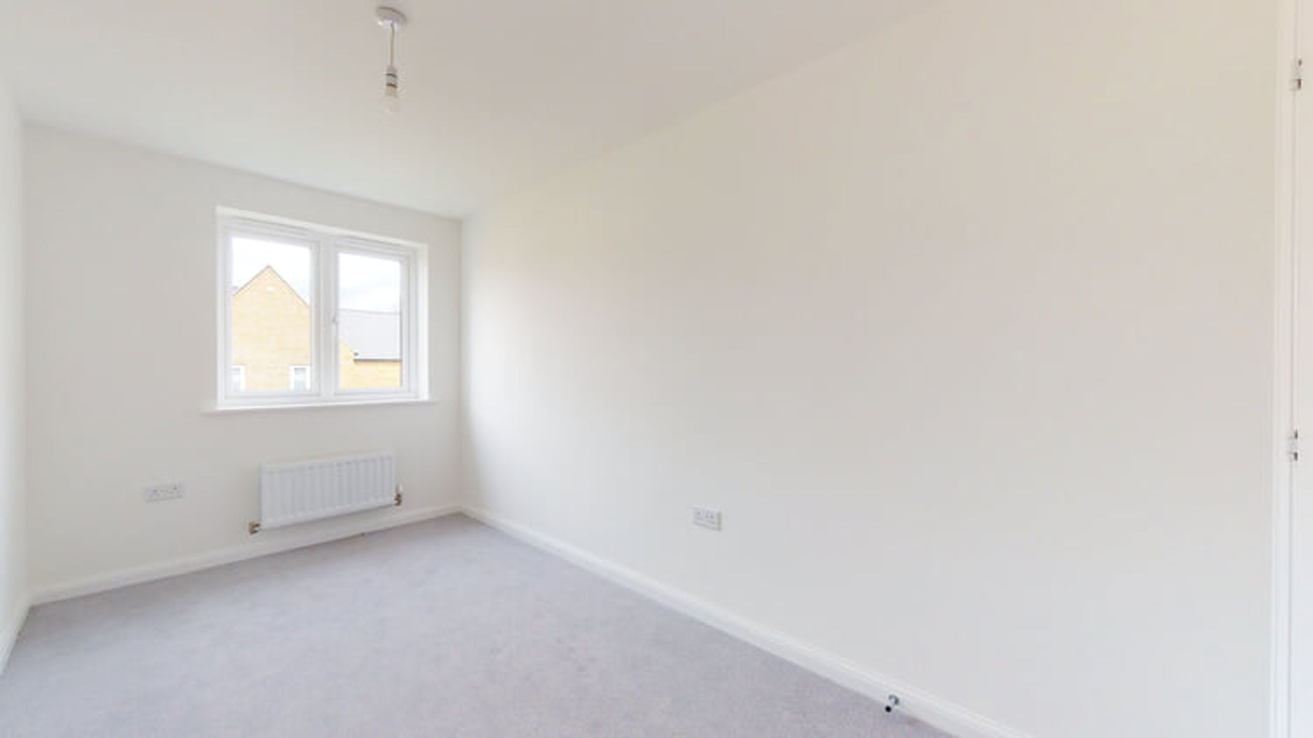 A bedroom with a window and a radiator.