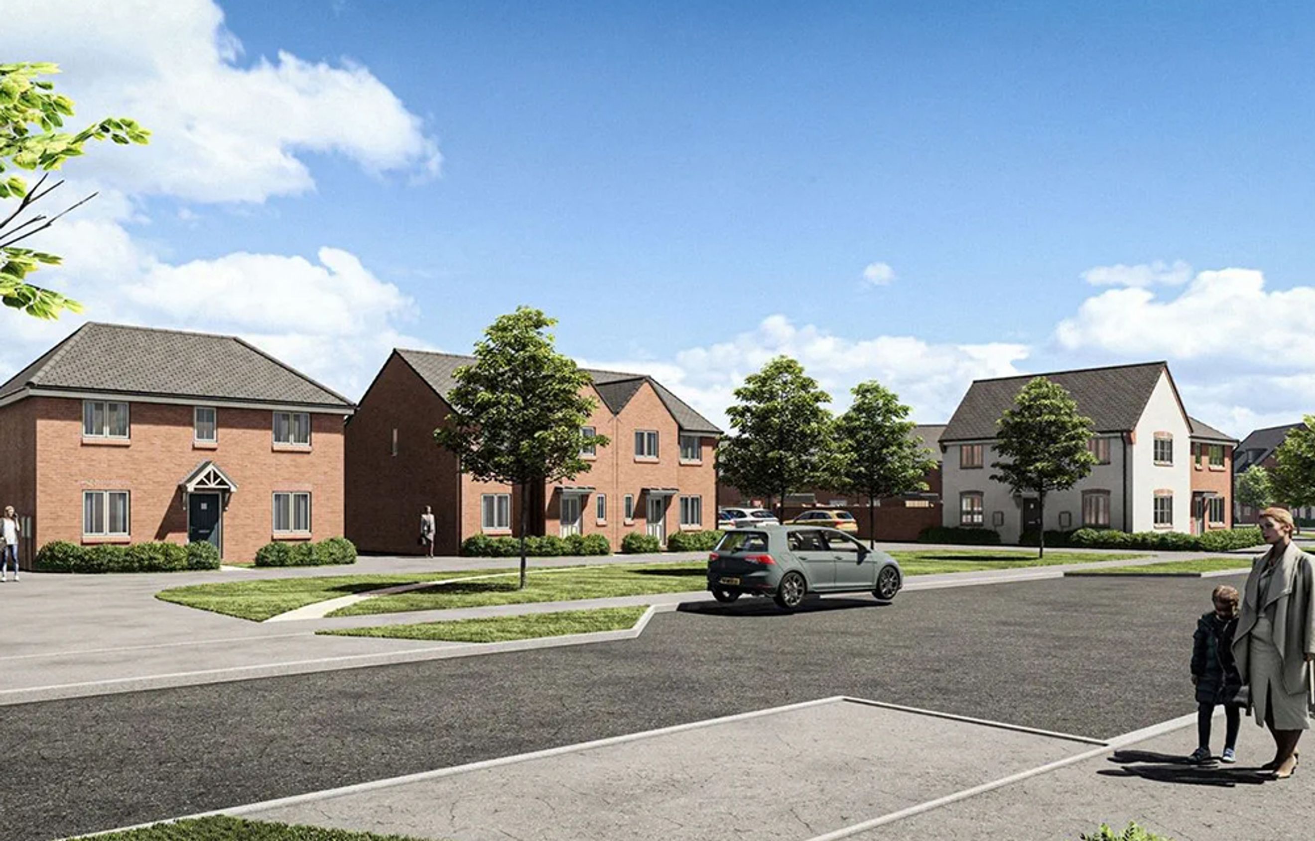 A street view of a modern housing development with brick and white houses, trees, cars, and people.