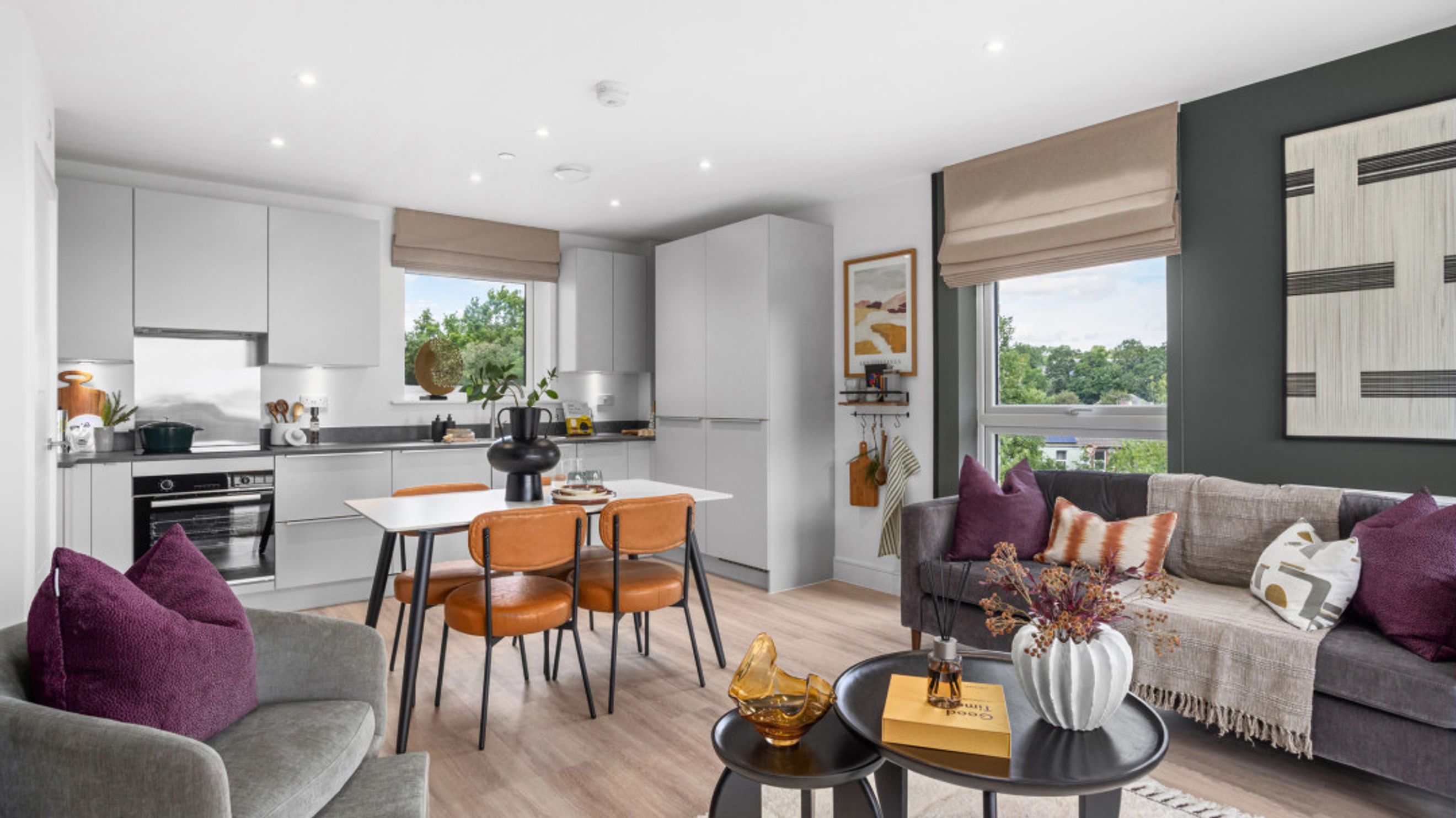 A living room and kitchen area with a dining table and chairs.