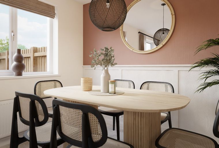 A dining room with an oval table, chairs, a mirror, and a plant.