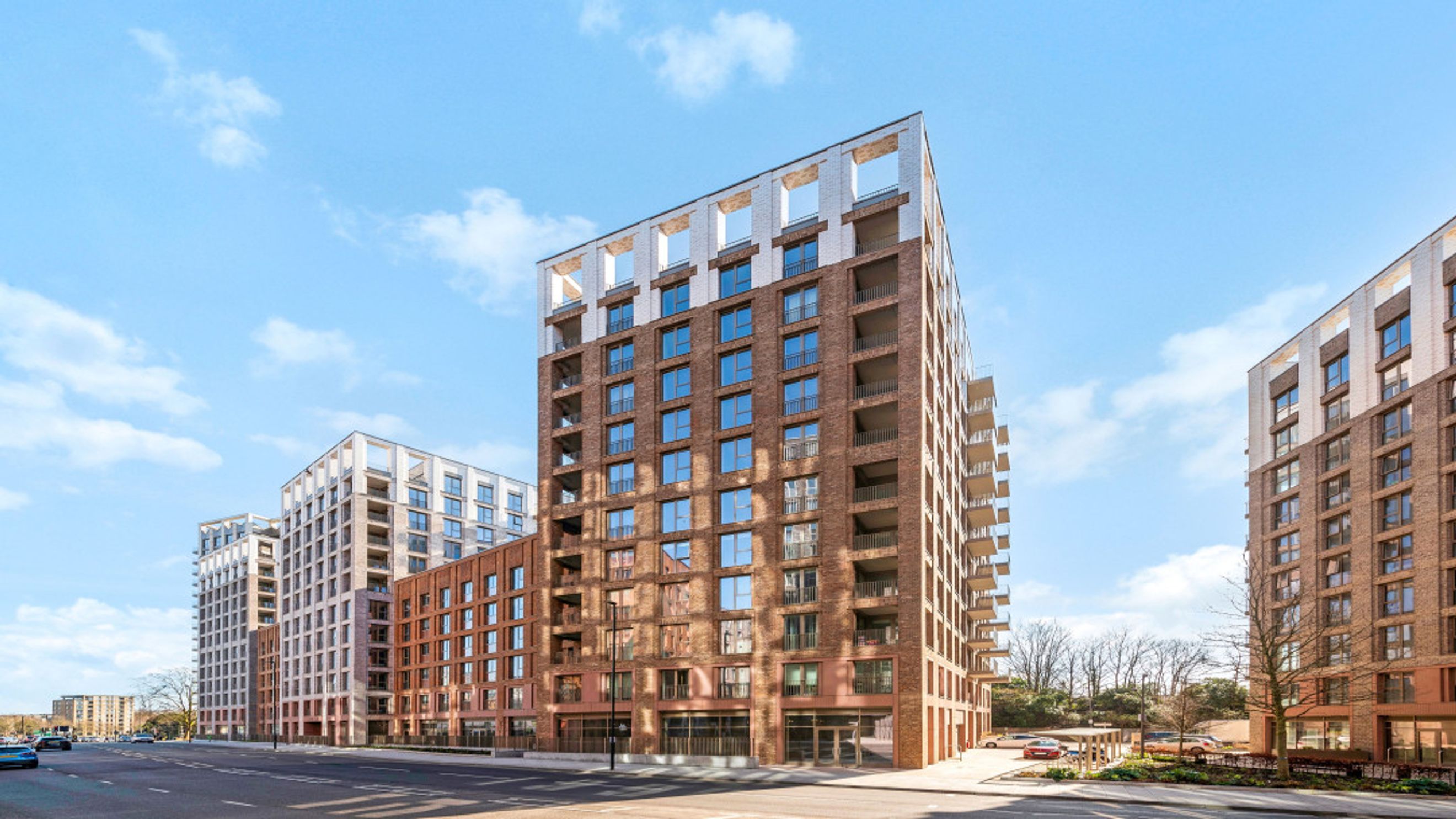 A modern apartment building with brick facades and balconies under a blue sky.