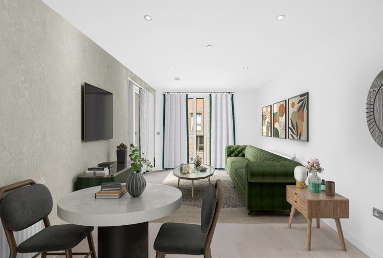 A living room with a green sofa, dining table, and artwork on the wall.