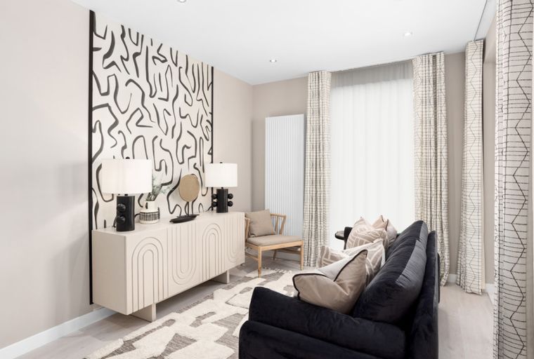 A living room with a sofa, sideboard, and abstract art.