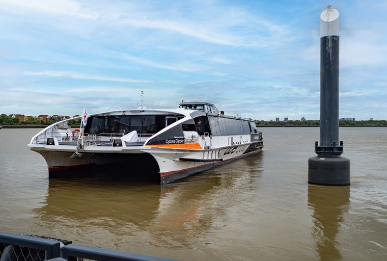 A catamaran ferry named Cyclone Clipper on the water next to a buoy.