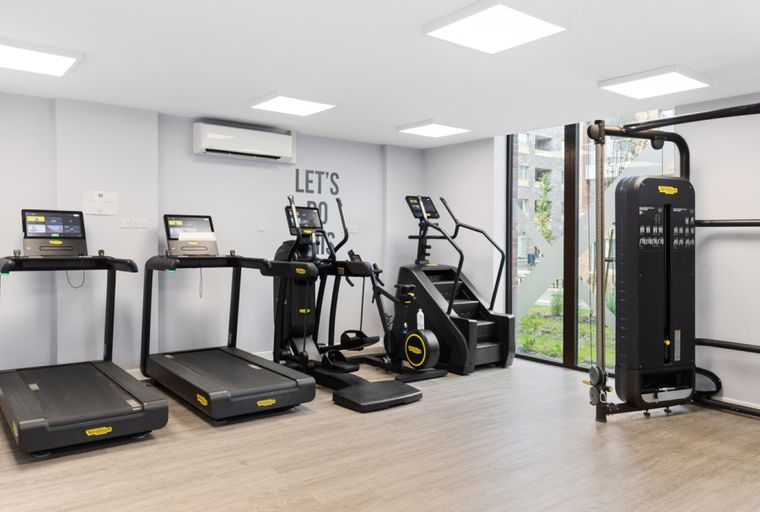 A gym with treadmills, an elliptical, a stair climber, and a cable machine.