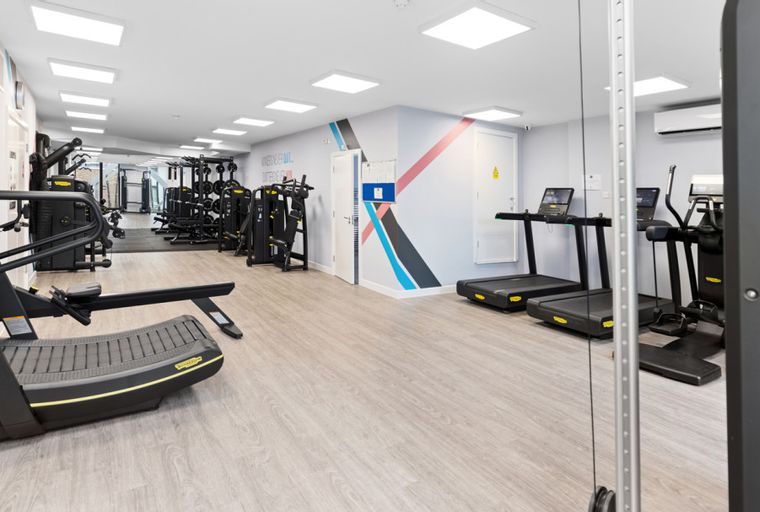 A gym with treadmills, weight machines, and other exercise equipment.