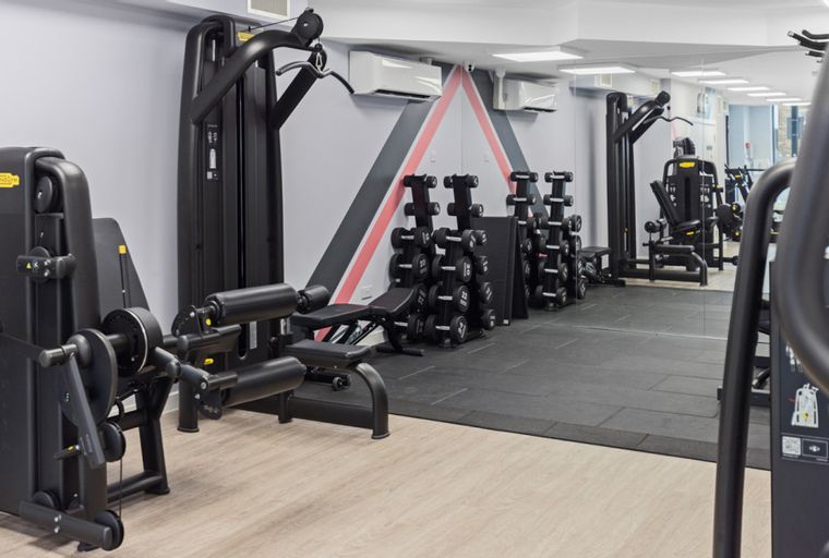 A gym with weight machines, dumbbells, and exercise equipment.