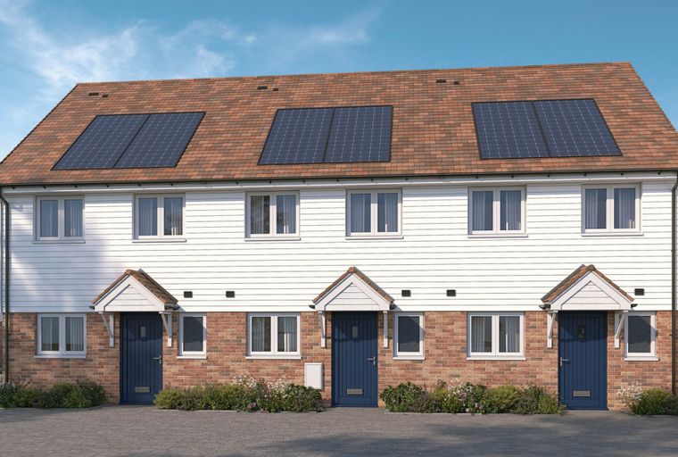 A row of modern townhouses with solar panels on the roof, white siding, and brick bases.