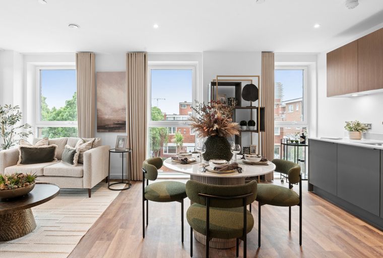 A living and dining area with a sofa, coffee table, dining table with chairs, and a kitchen.