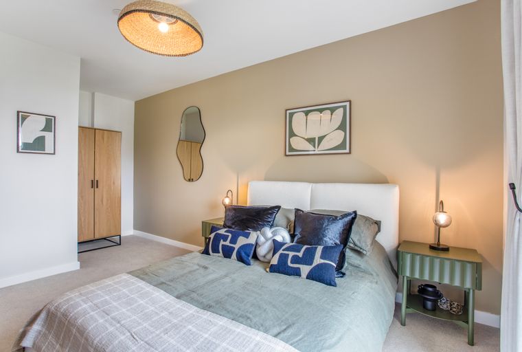 A bedroom with a bed, pillows, a nightstand, and a wardrobe.