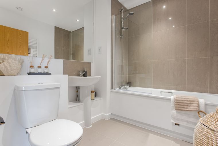 A bathroom with a toilet, sink, and bathtub with a shower.