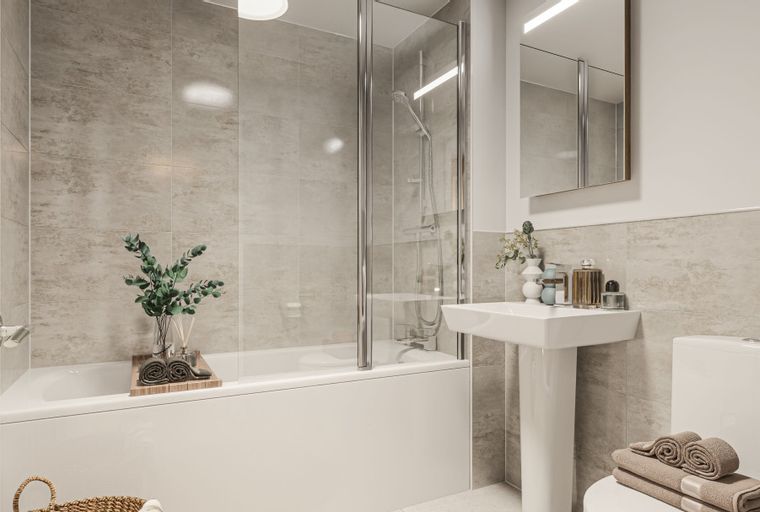 A bathroom with a bathtub, shower screen, sink, and toilet.