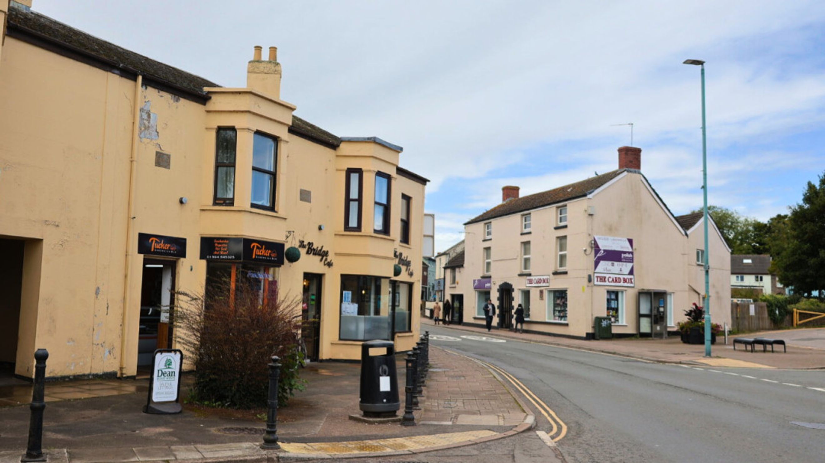A street view of commercial buildings with storefronts and a road.