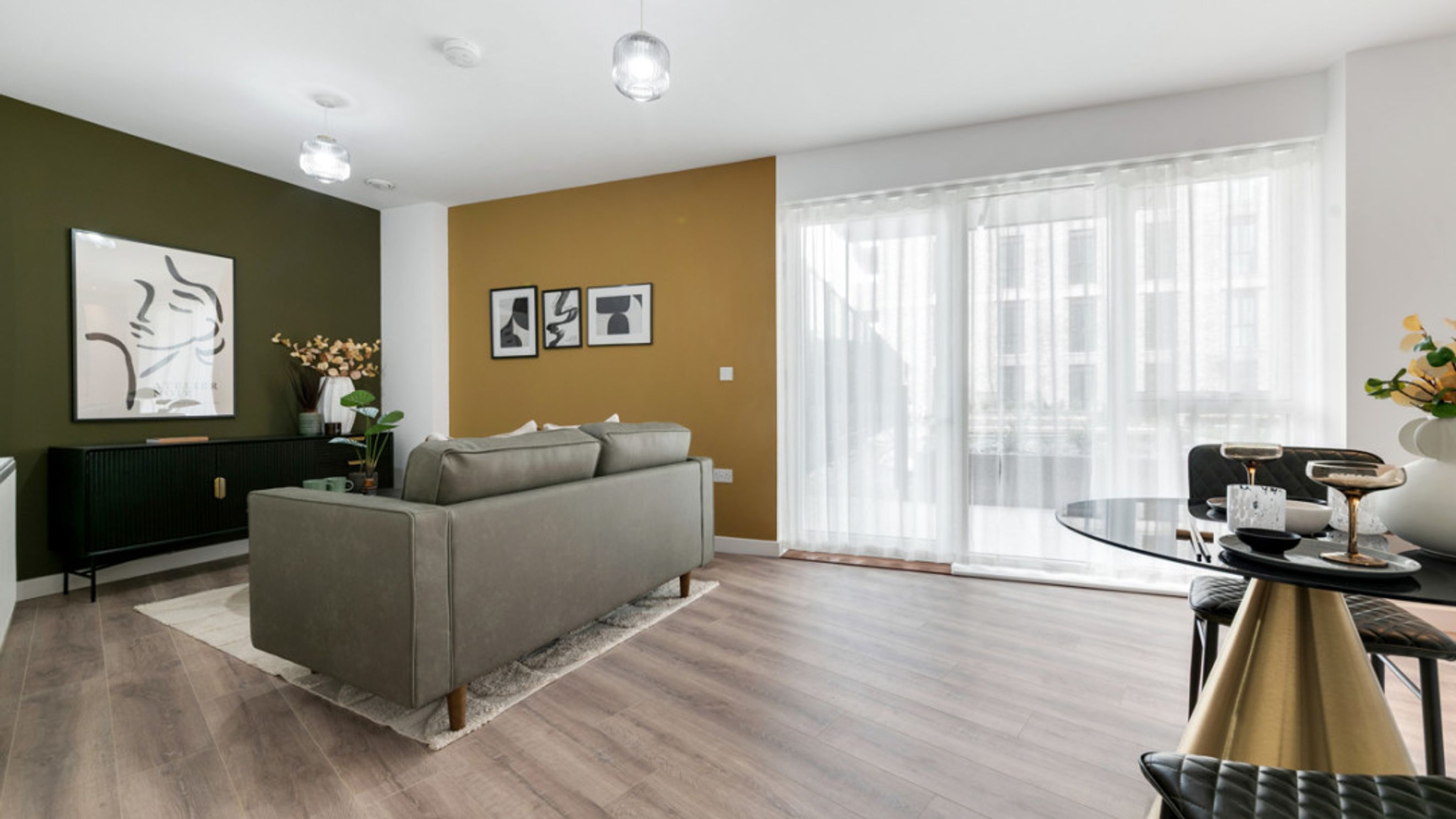 A living room with a sofa, a cabinet, and a dining table.