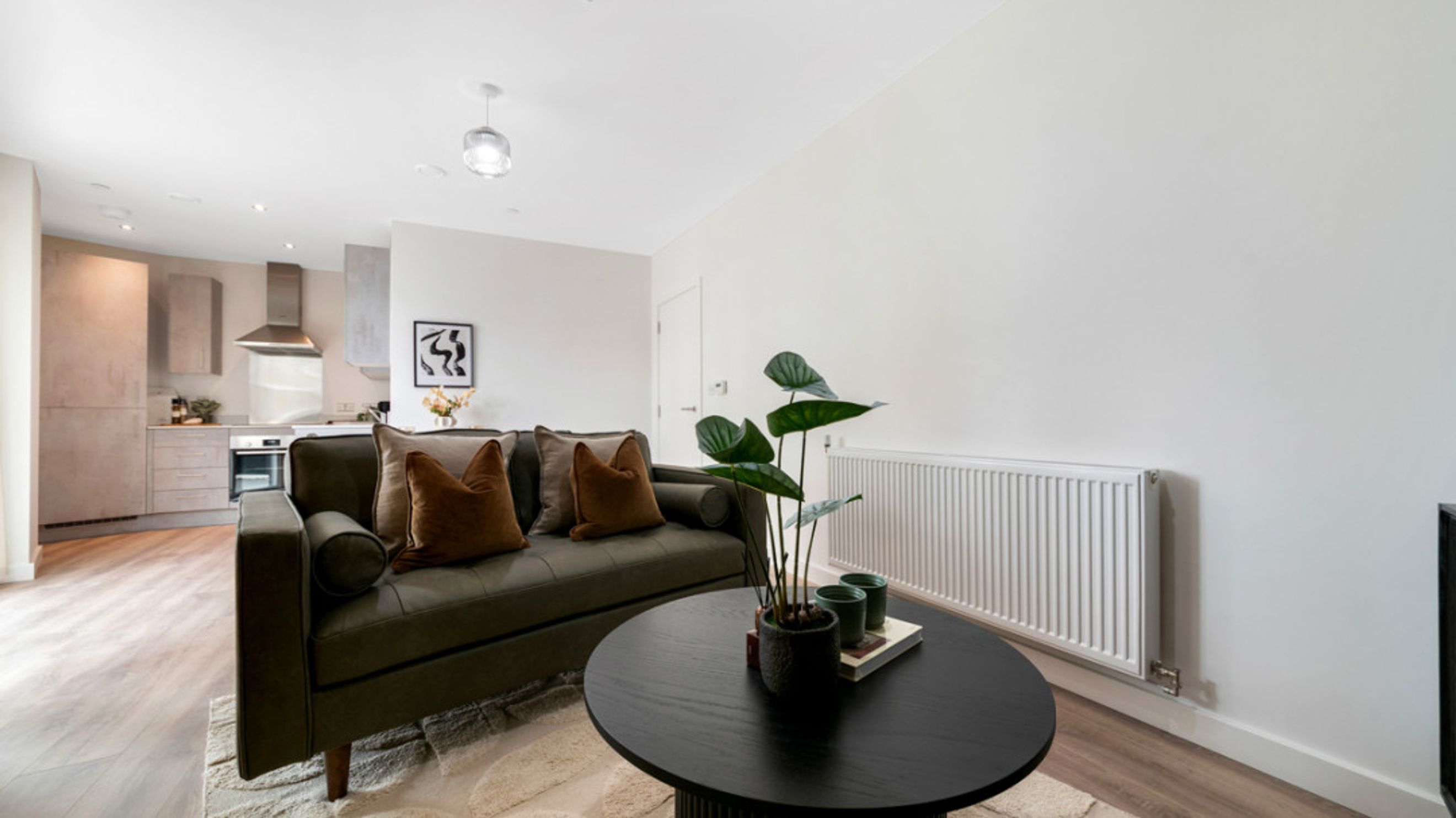 A living room with a sofa, coffee table, and a radiator.