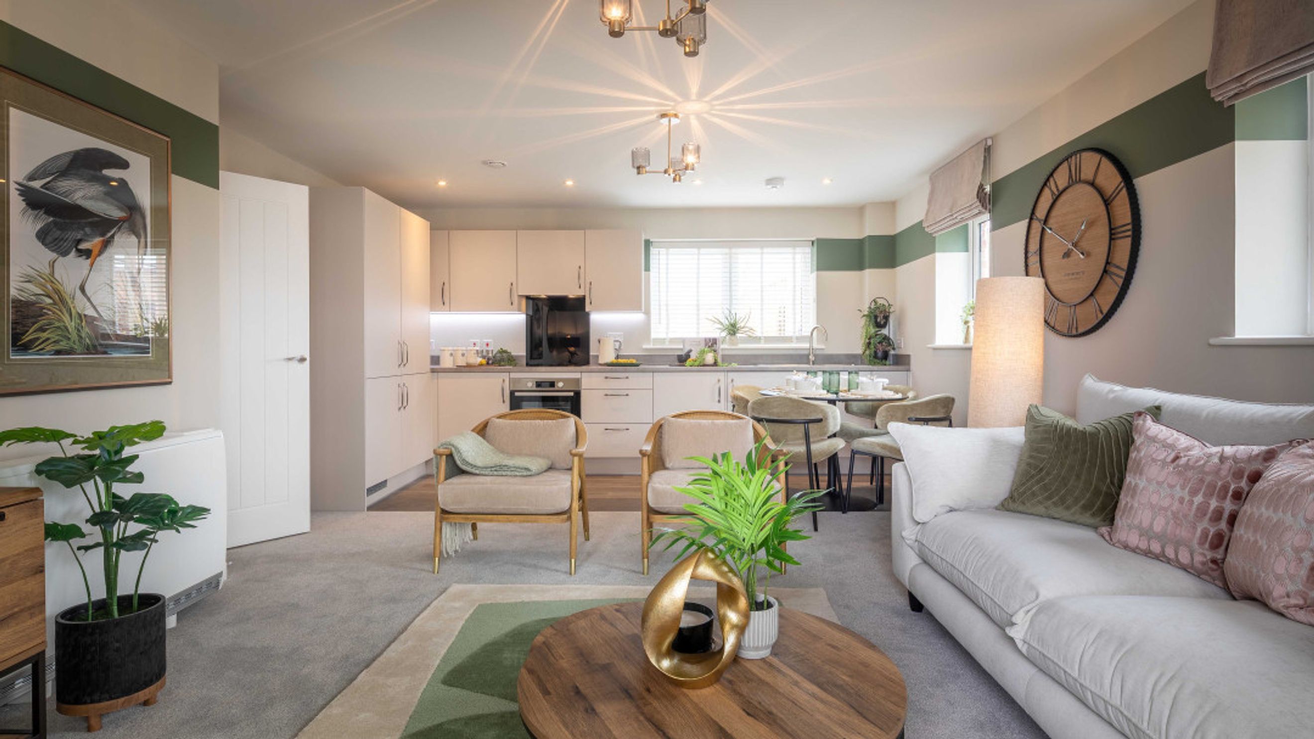 A living room and kitchen area with a sofa, chairs, dining table, and kitchen cabinets.