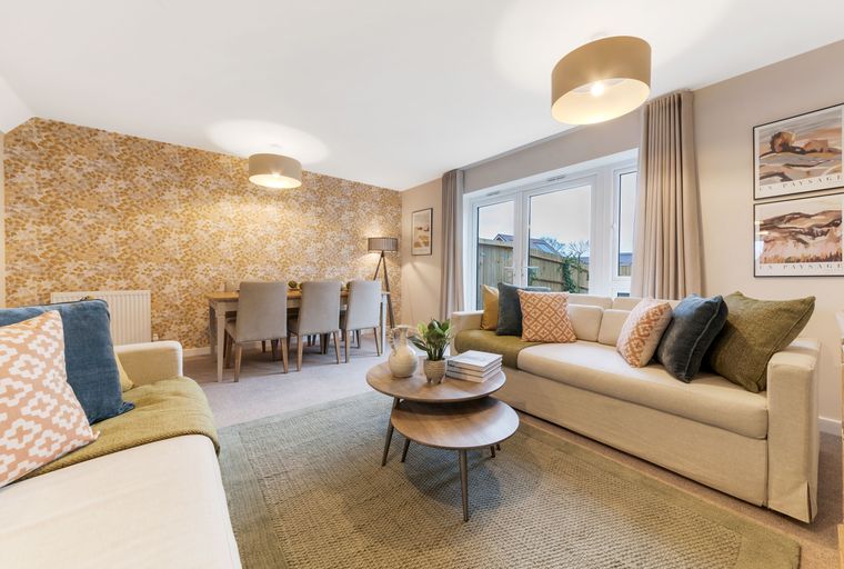 A living and dining room with a sofa, coffee table, dining table, and chairs.