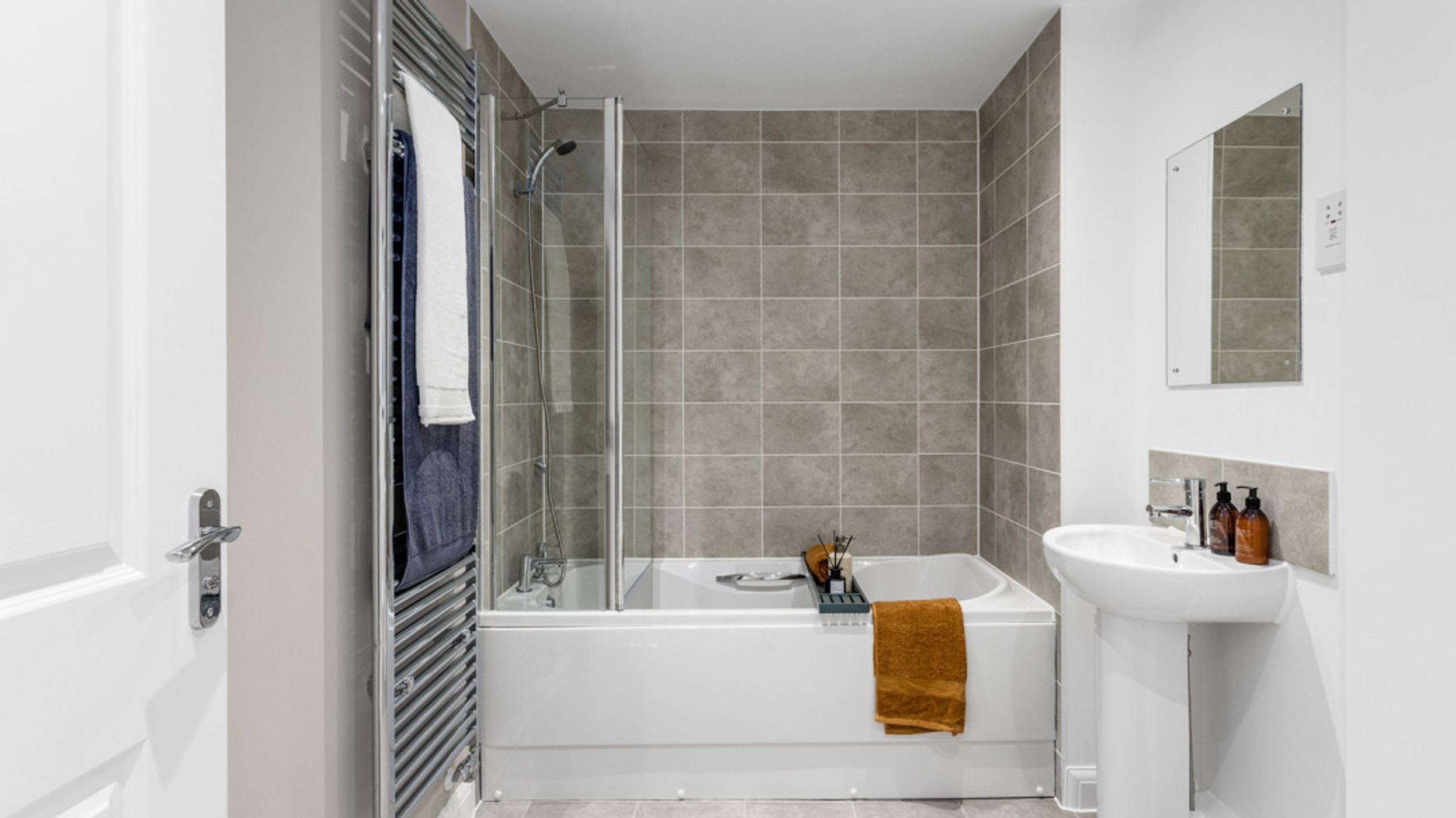 A bathroom with a bathtub, shower, sink, and mirror.