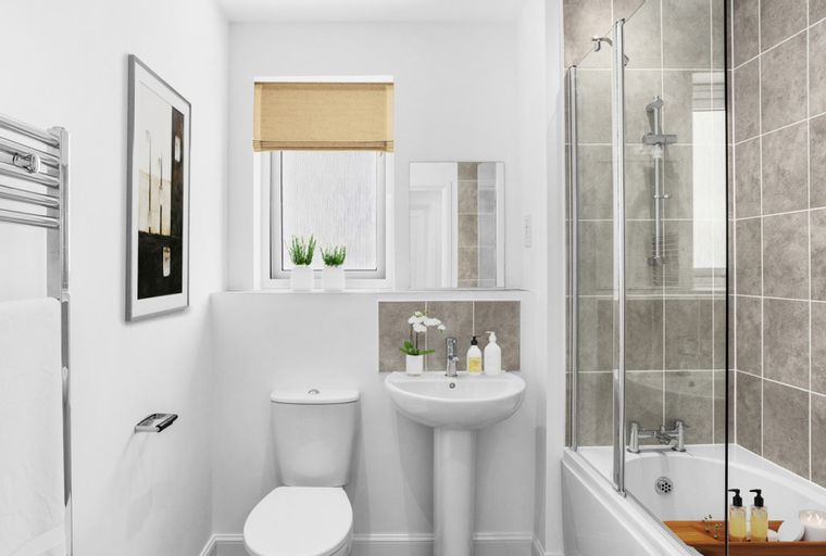 A bathroom with a toilet, sink, bathtub with shower, and a towel warmer.
