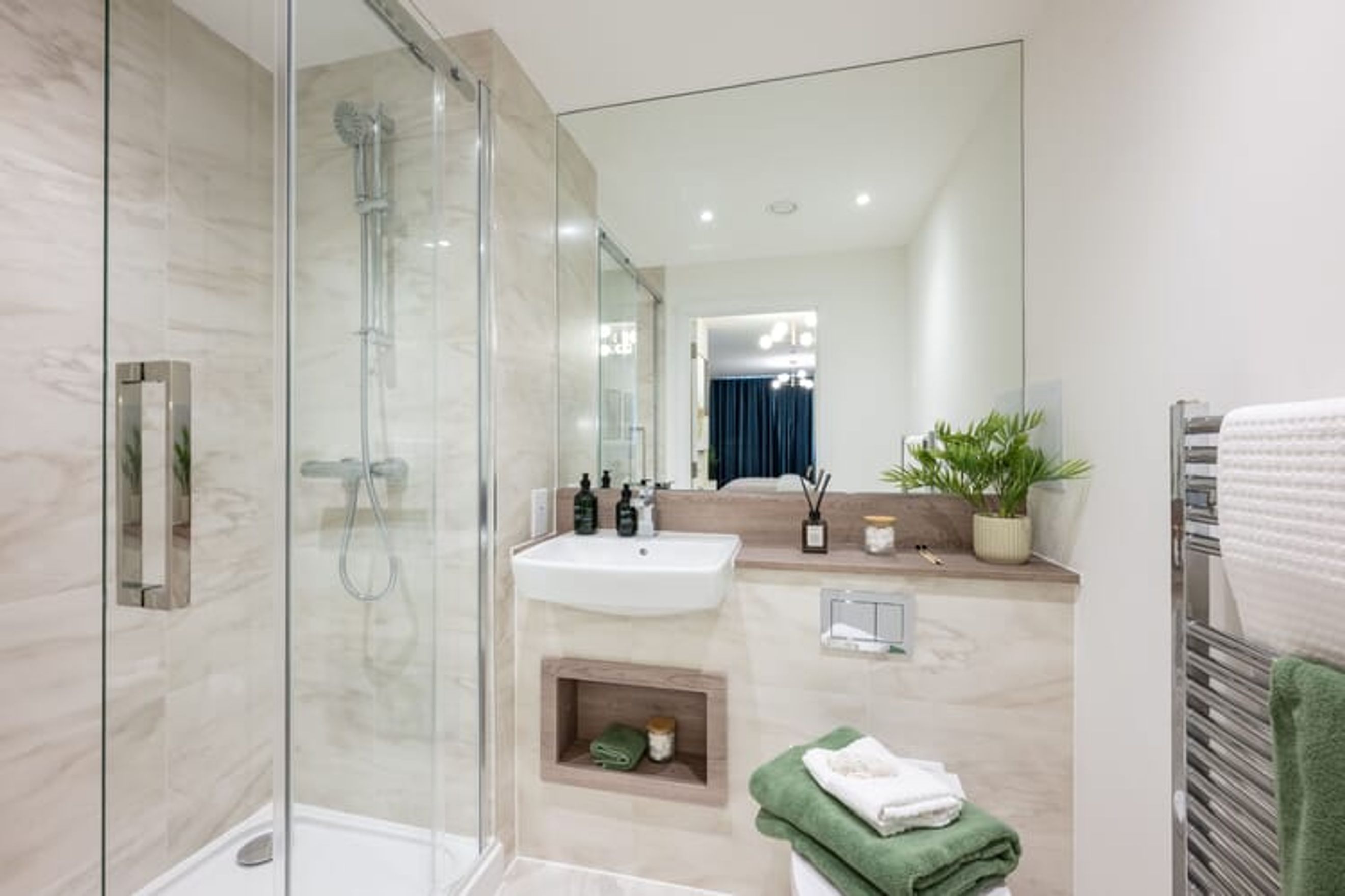 A modern bathroom with a glass shower, vessel sink, and a large mirror.
