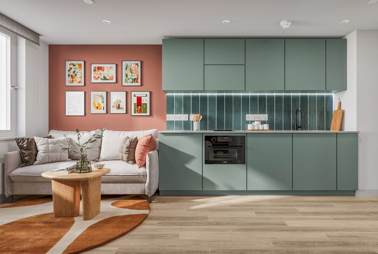 A living room and kitchen area with a sofa, coffee table, and mint green cabinets.