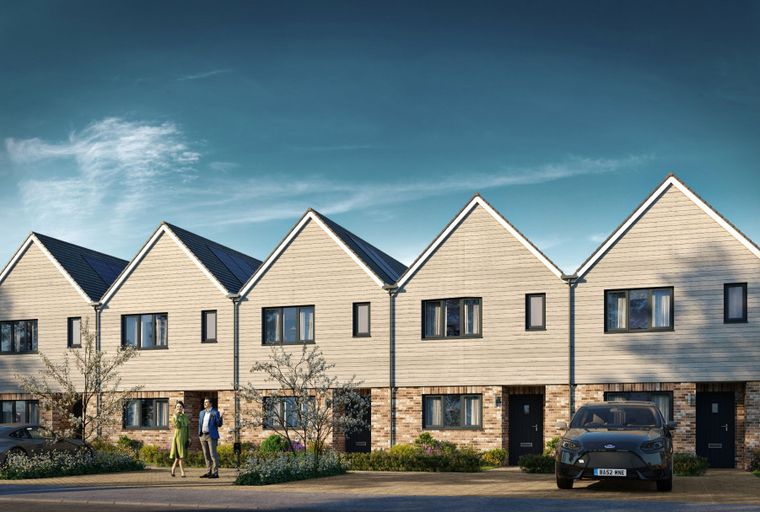 A row of modern townhouses with brick and timber facades, solar panels on the roofs, and parked cars in the driveways.