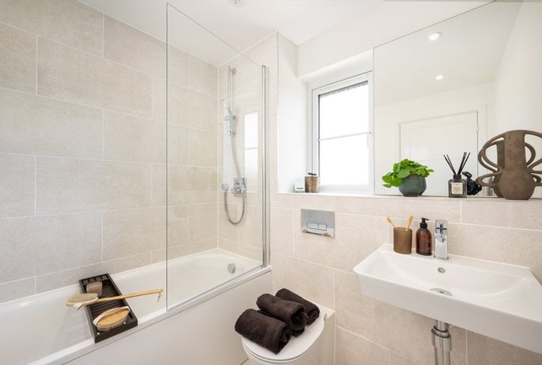 A bathroom with a bathtub, shower, sink, and mirror.