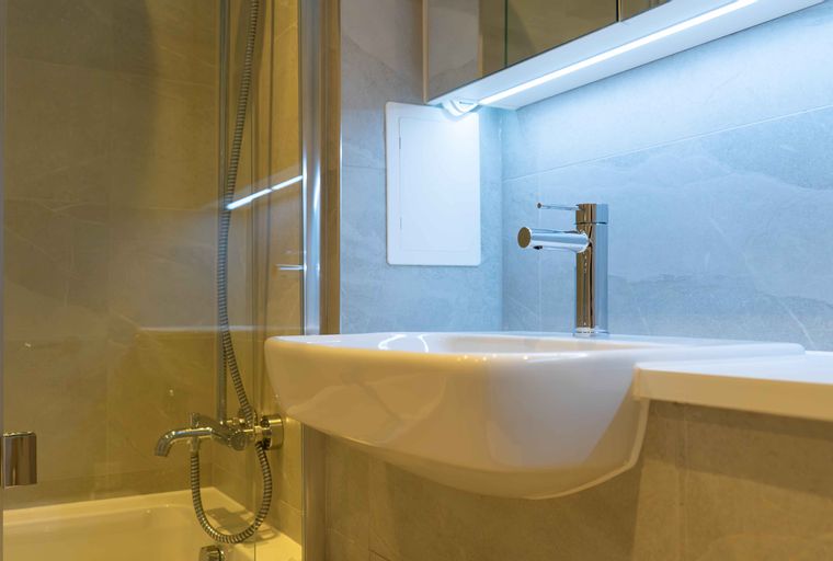A bathroom with a sink, faucet, bathtub, and shower.