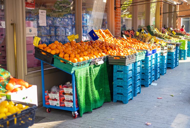 A fruit stand displaying a large quantity of oranges in crates.