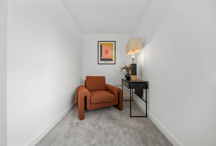 A reading nook with an armchair, a console table, and a lamp.