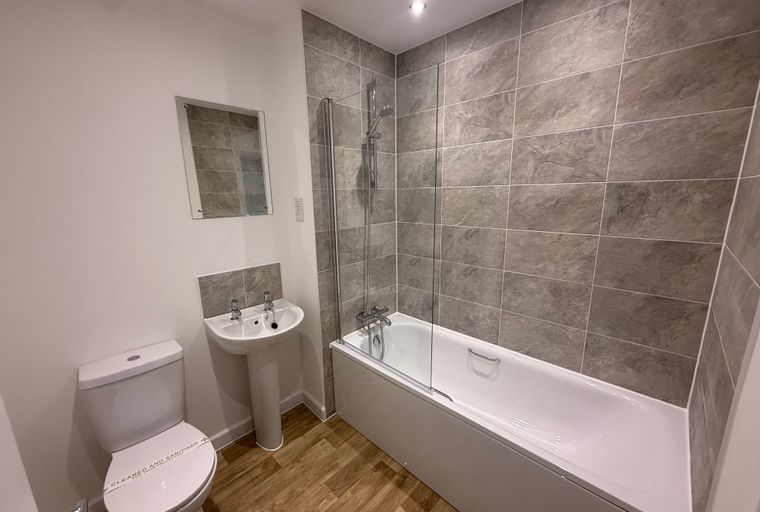 A bathroom with a toilet, sink, and bathtub.
