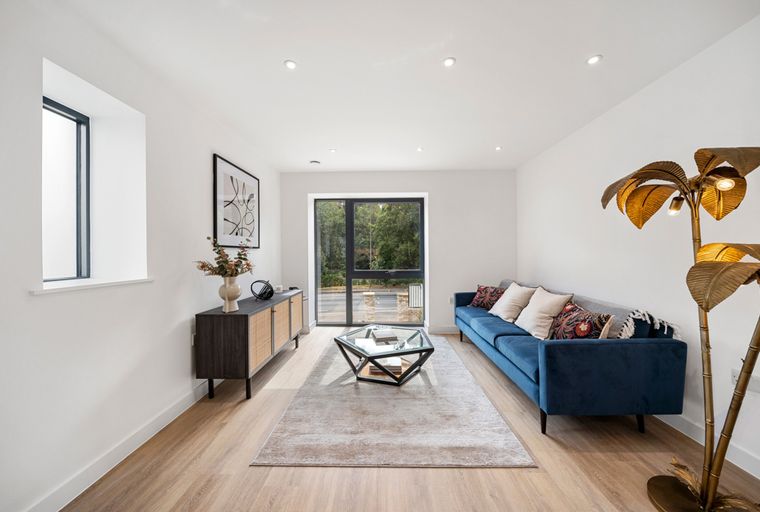 A living room with a blue sofa, coffee table, rug, and a floor lamp.