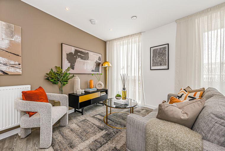 A living room with a sofa, armchair, coffee table, and media console.