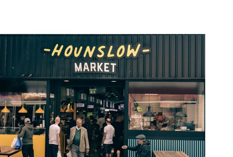 A storefront for Hounslow Market with people entering and exiting.