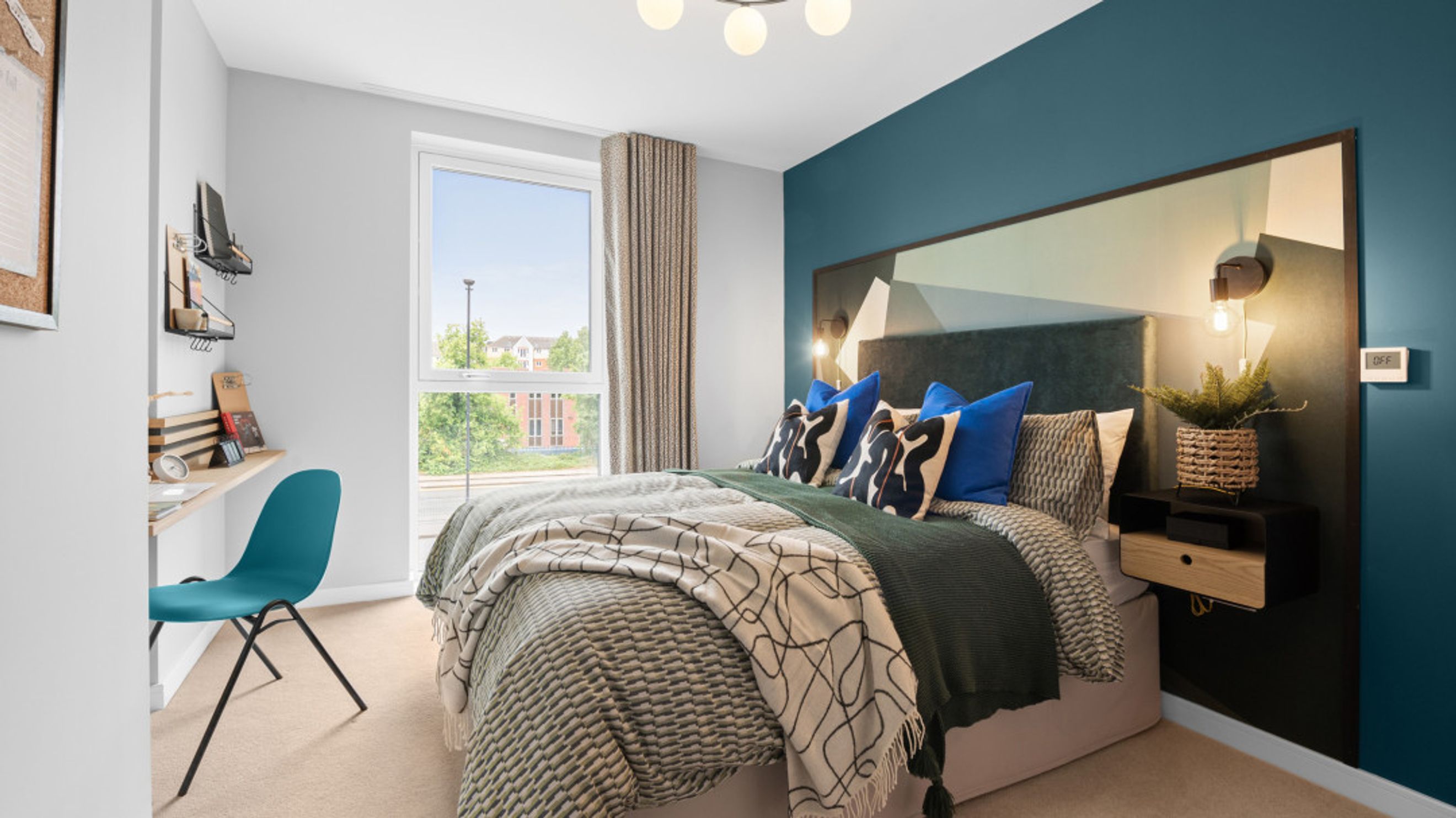 A bedroom with a bed, pillows, a desk, and a chair.