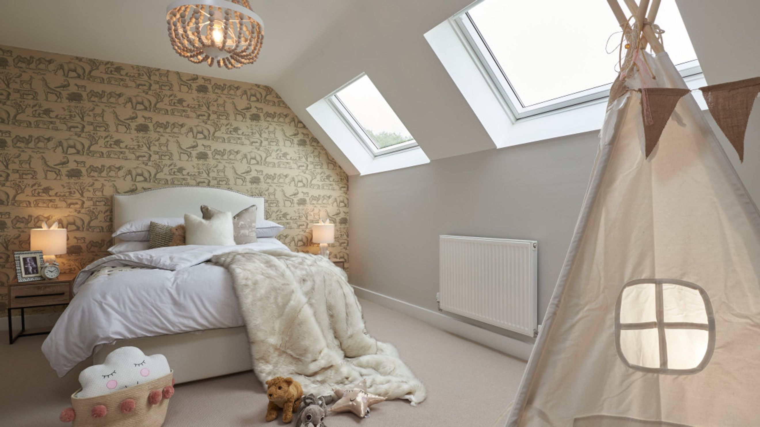 A bedroom with a bed, wallpaper, skylights, and a teepee tent.