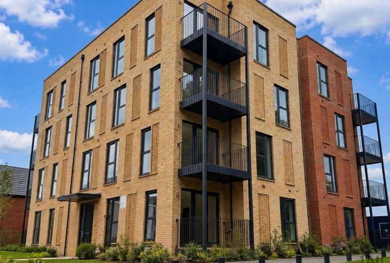 A modern apartment building with brick facades and black balconies.
