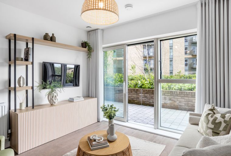 A living room with a TV, entertainment unit, sofa, and a coffee table.
