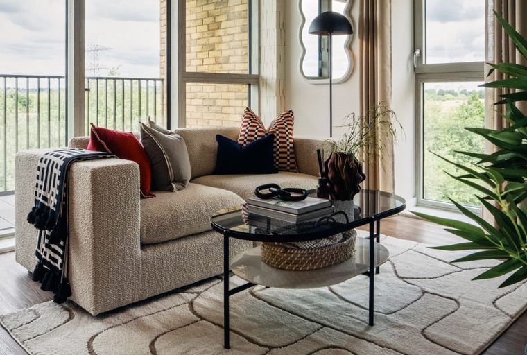 A living room with a sectional sofa, coffee table, and large windows.