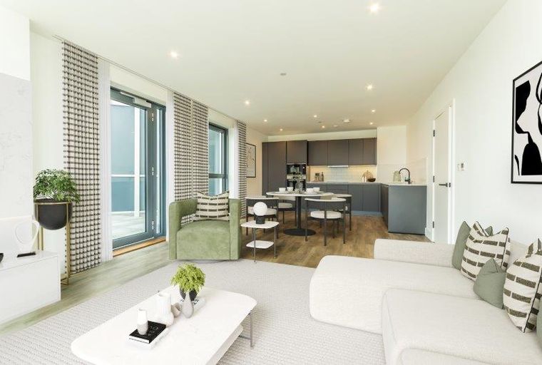 A living room and kitchen area with a sofa, chairs, and dining table.