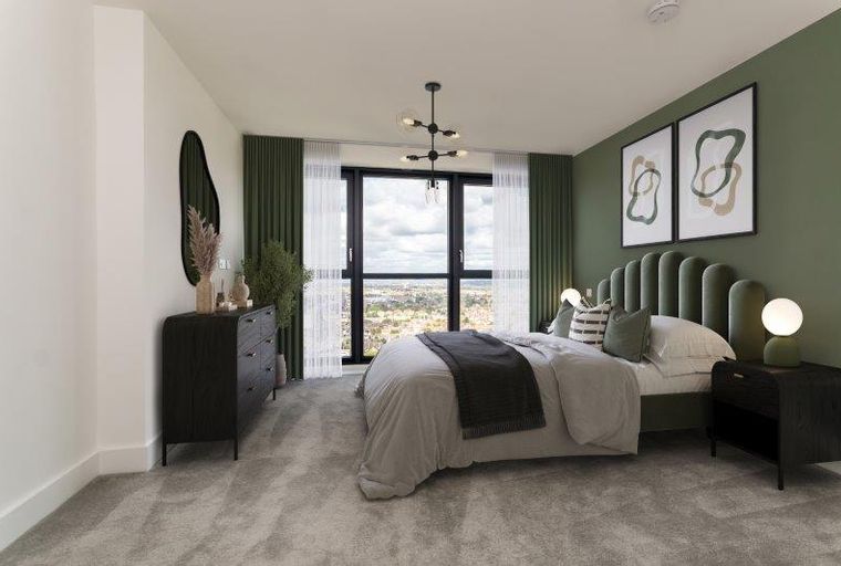 A bedroom with a bed, nightstands, a dresser, and a large window.