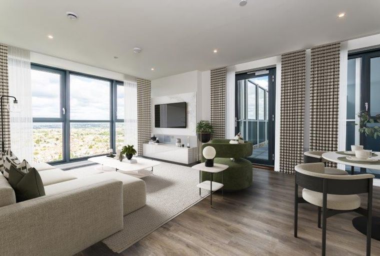 A living room with a sofa, coffee table, television, and large windows.
