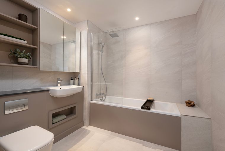 A bathroom with a toilet, sink, and bathtub with a shower.