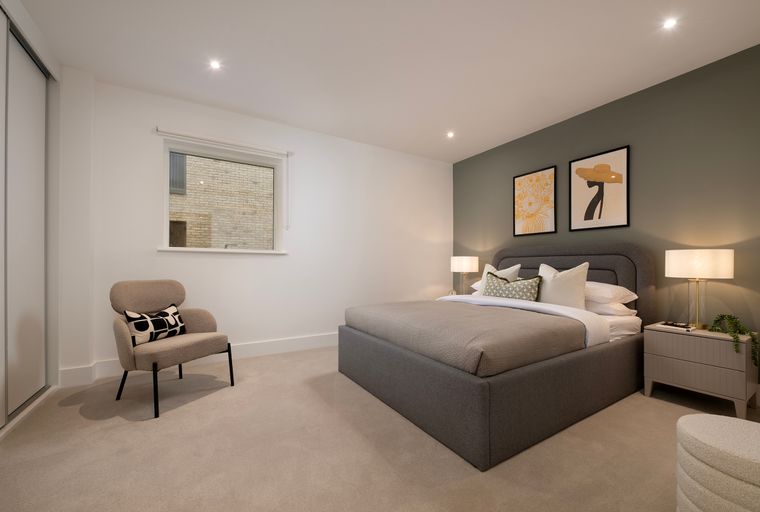 A bedroom with a bed, a chair, and a window.