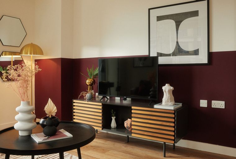 A living room with a television, entertainment unit, coffee table, and decorative items.
