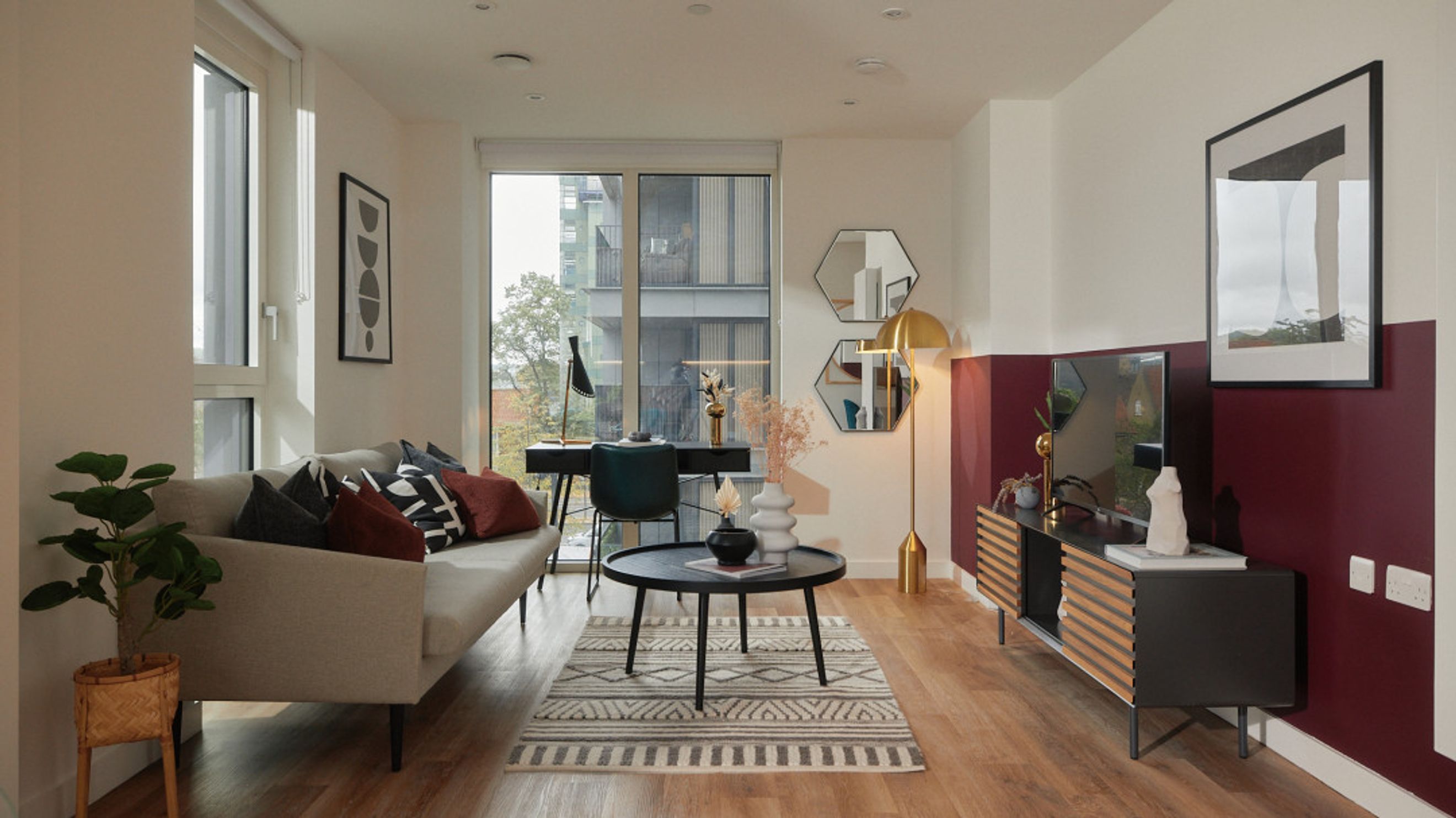 A living room with a sofa, coffee table, desk, and television.
