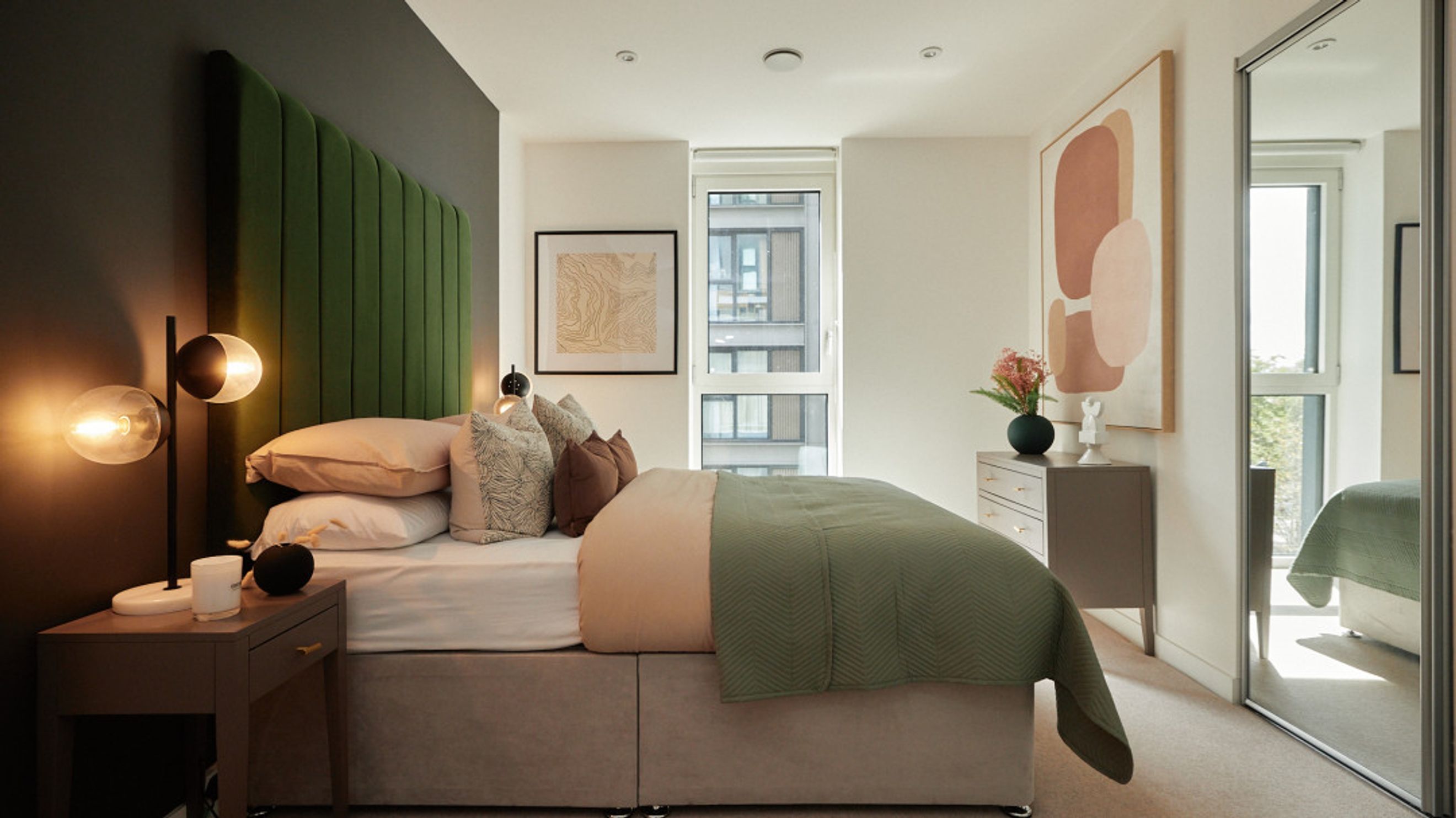A bedroom with a bed, bedside tables, and a dresser.