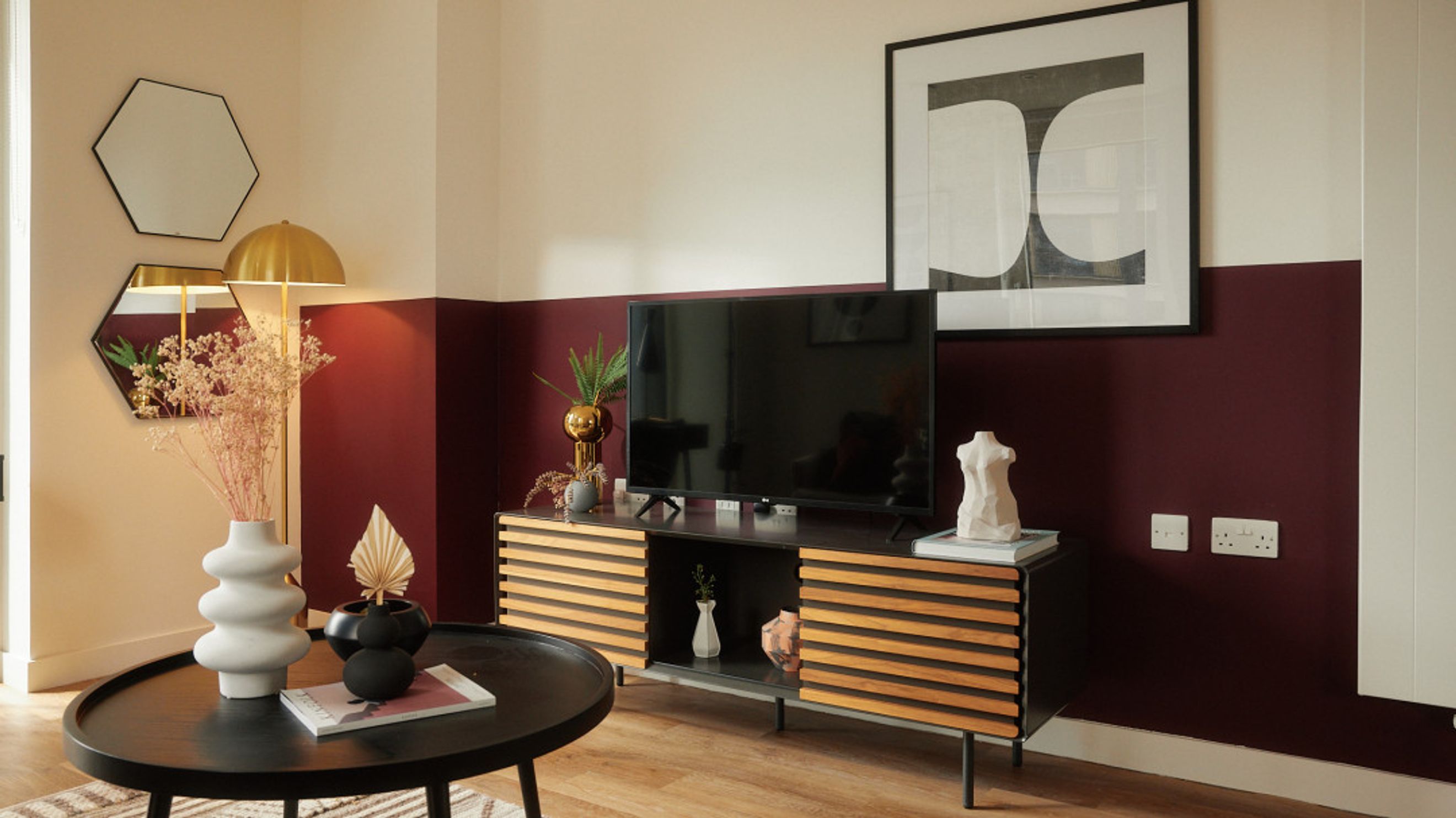 A living room with a television, entertainment unit, coffee table, and decorative items.